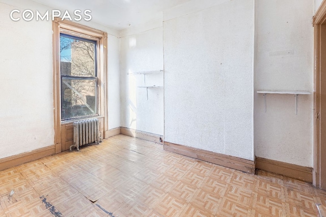 empty room with radiator and light parquet floors