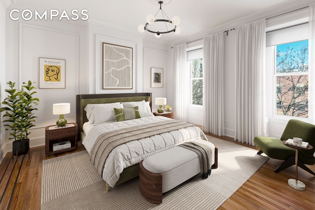 bedroom with a notable chandelier, a decorative wall, and wood finished floors