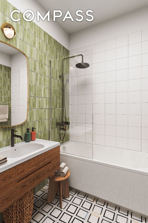 bathroom featuring tile walls, tiled shower / bath combo, and sink