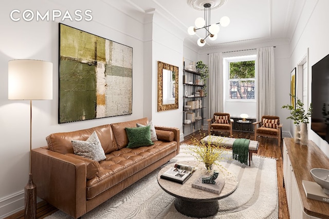 sitting room featuring crown molding, wood-type flooring, and an inviting chandelier