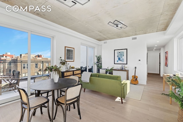 dining area featuring light wood finished floors and visible vents