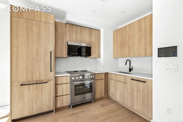 kitchen with modern cabinets, light countertops, and high end stainless steel range