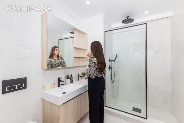 full bathroom with a stall shower, recessed lighting, vanity, and tile walls