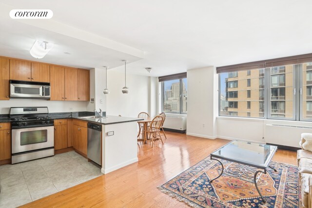 kitchen featuring a peninsula, a sink, visible vents, appliances with stainless steel finishes, and dark countertops