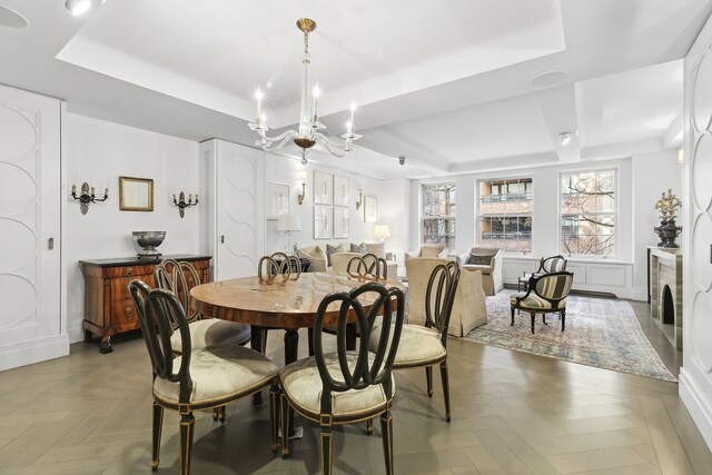 dining area featuring a tray ceiling and an inviting chandelier