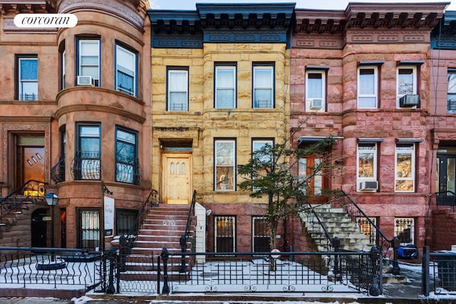 multi unit property featuring a fenced front yard and cooling unit