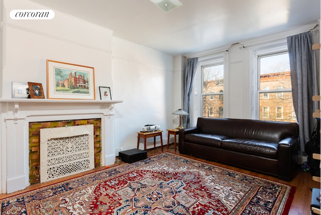 living room featuring a fireplace, wood finished floors, and visible vents