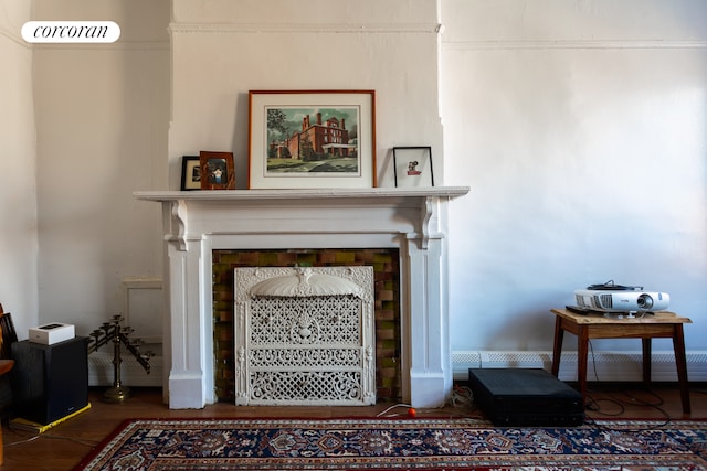 living area featuring wood finished floors and a fireplace with flush hearth