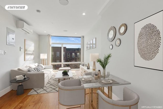 living room featuring visible vents, baseboards, a wall unit AC, light wood-style floors, and floor to ceiling windows