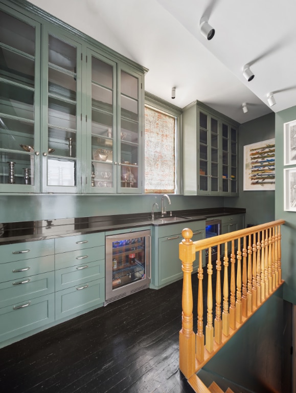 kitchen featuring sink, beverage cooler, dark hardwood / wood-style floors, and green cabinets