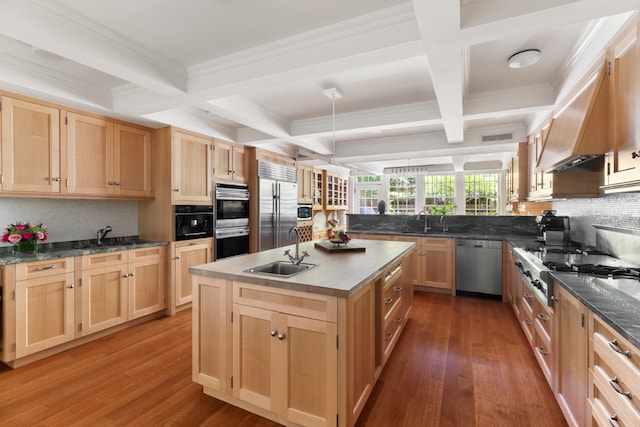 kitchen featuring built in appliances, sink, dark hardwood / wood-style flooring, light brown cabinetry, and a kitchen island with sink