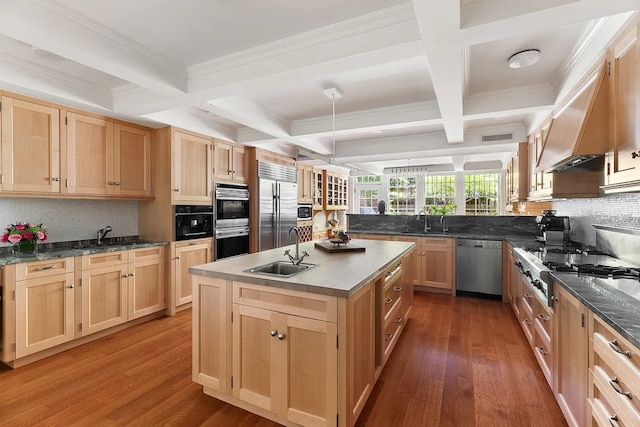 kitchen featuring hardwood / wood-style flooring, a center island, built in appliances, sink, and light brown cabinets