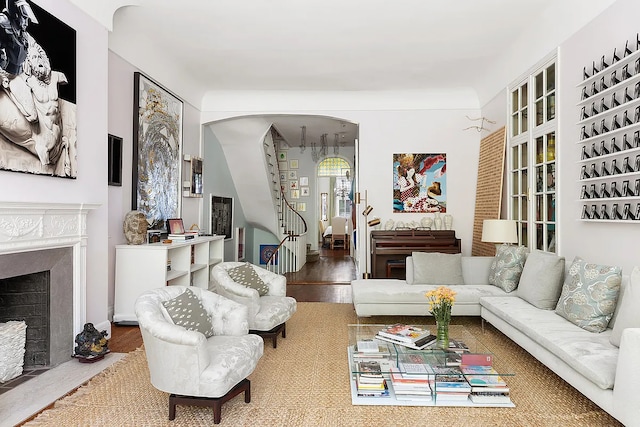 134 E 62nd St, New York City, NY 10065 - living area featuring arched walkways, a fireplace with flush hearth, and wood finished floors