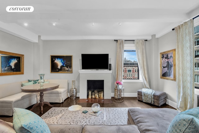 living room featuring beam ceiling, visible vents, a fireplace, and wood finished floors