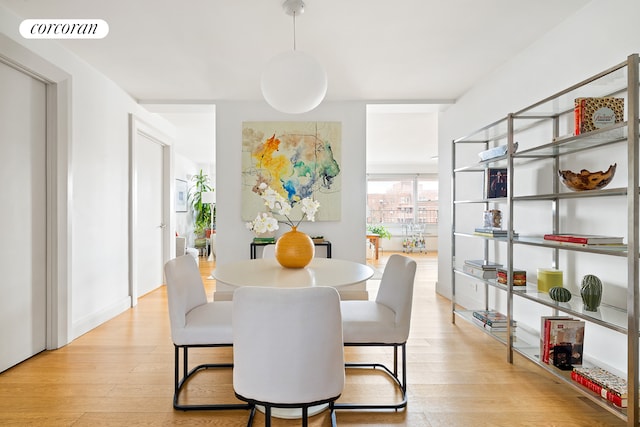 dining space featuring light wood-style flooring and visible vents