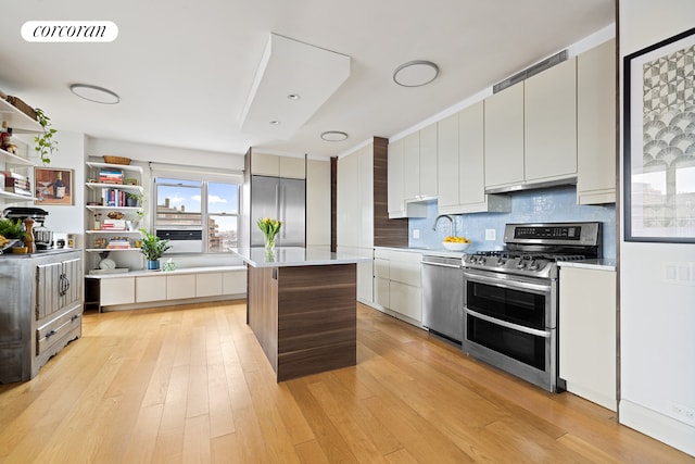 kitchen with stainless steel appliances, modern cabinets, light countertops, a center island, and tasteful backsplash