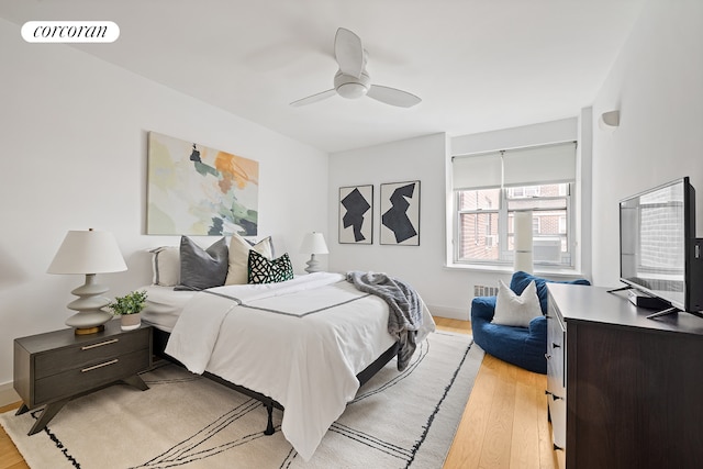 bedroom with light wood-type flooring, a ceiling fan, and baseboards