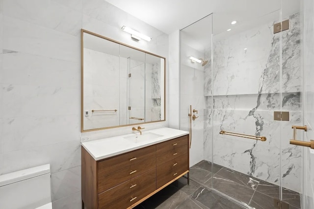 bathroom featuring vanity, toilet, tile walls, and a tile shower