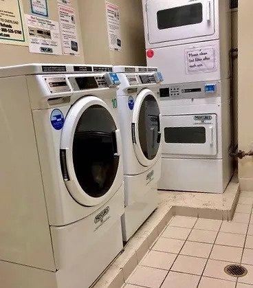 community laundry room with independent washer and dryer, light tile patterned floors, and stacked washer / dryer