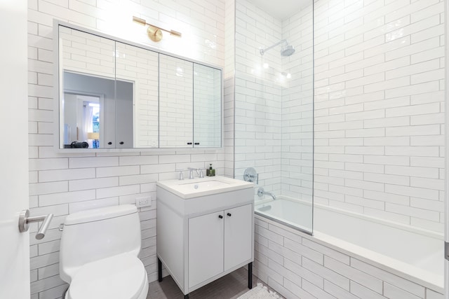 184 Kent Ave Unit B312, New York City, NY 11249 - bathroom featuring tile walls, tiled shower / bath, vanity, and toilet