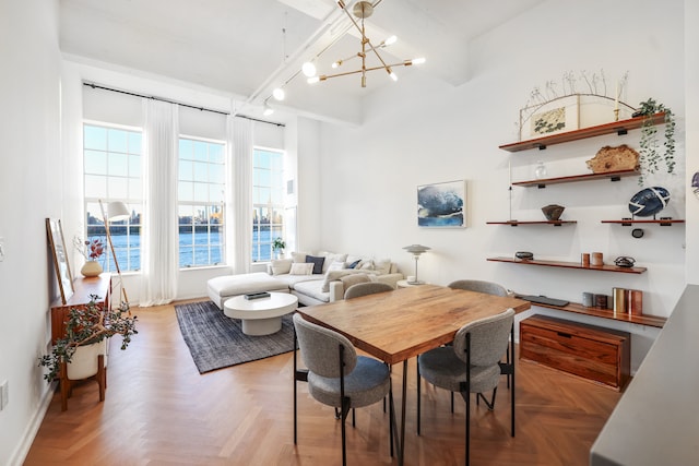 dining area featuring rail lighting, a notable chandelier, and baseboards