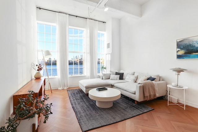 living room featuring a water view, rail lighting, and baseboards