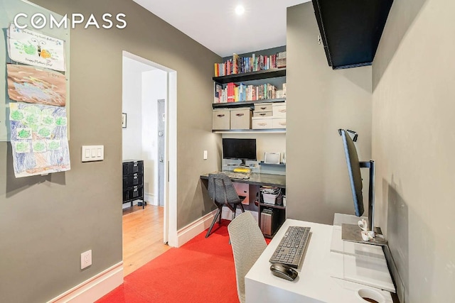 home office with baseboards and wood finished floors