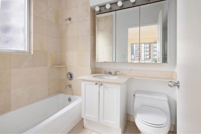 full bathroom featuring vanity, tiled shower / bath, and toilet