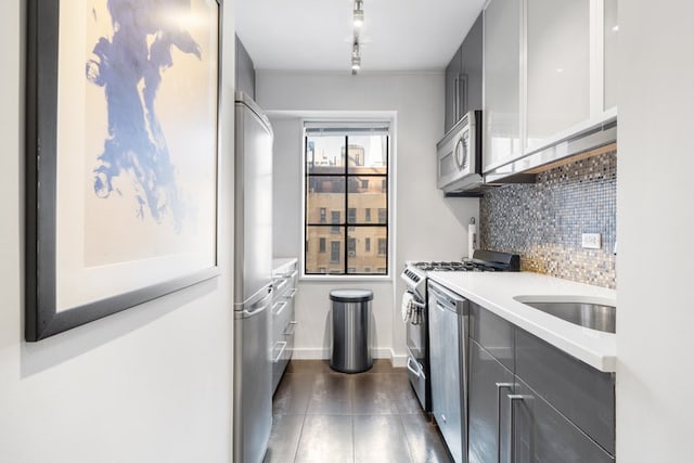 kitchen featuring appliances with stainless steel finishes, gray cabinets, light countertops, and tasteful backsplash