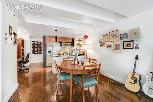 dining area with dark wood-type flooring and baseboards