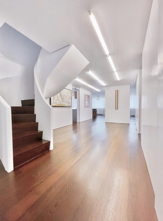 45 W 67th St Unit 27D, New York City, NY 10023 - unfurnished living room featuring wood finished floors and stairs