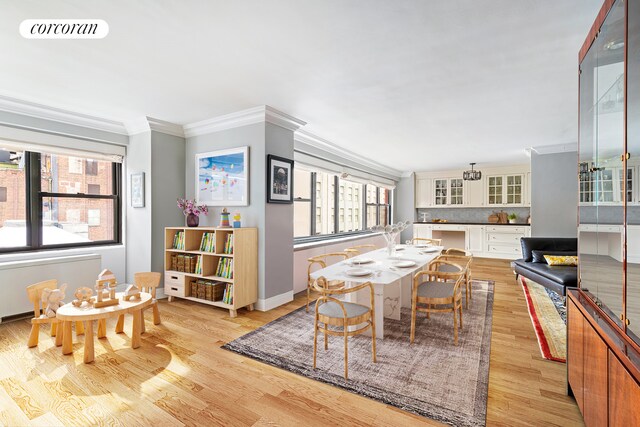 dining area with visible vents, crown molding, light wood-style flooring, and baseboards