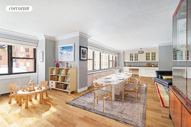 dining room featuring crown molding, baseboards, visible vents, and light wood finished floors