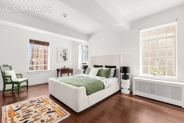 bedroom featuring radiator heating unit and dark hardwood / wood-style floors