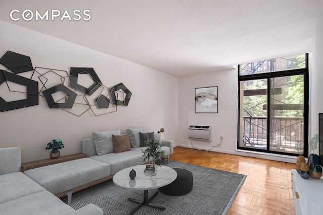 living area featuring a wall mounted air conditioner and baseboards