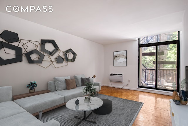 living area featuring an AC wall unit and baseboards