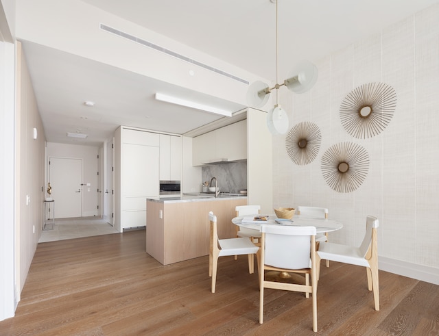 dining area with light wood-type flooring and baseboards