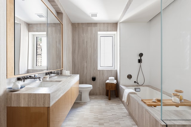 bathroom featuring toilet, tub / shower combination, and double vanity