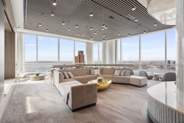 living room featuring expansive windows, a water view, and a healthy amount of sunlight
