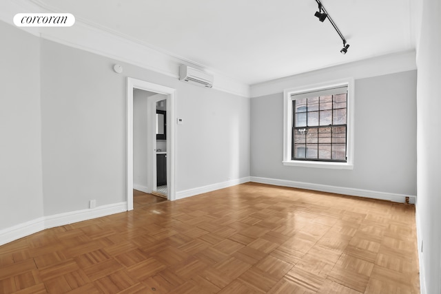 unfurnished room with track lighting, a wall mounted air conditioner, visible vents, and baseboards