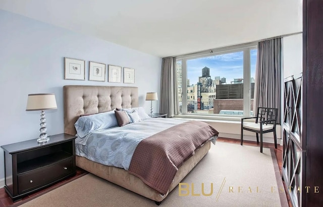 bedroom with wood finished floors and a city view