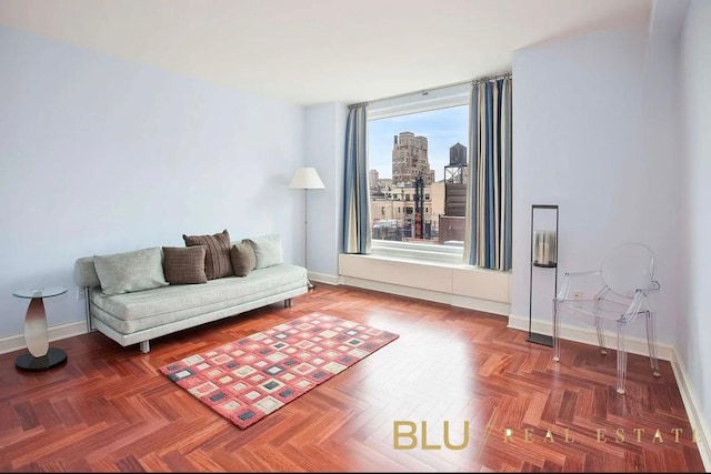 living area featuring baseboards and a view of city