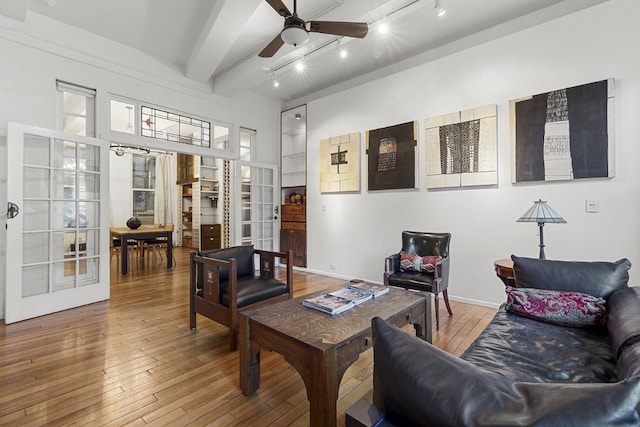 interior space featuring french doors, ceiling fan, beamed ceiling, and wood finished floors