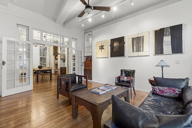 living room featuring french doors, hardwood / wood-style floors, ceiling fan, track lighting, and beam ceiling
