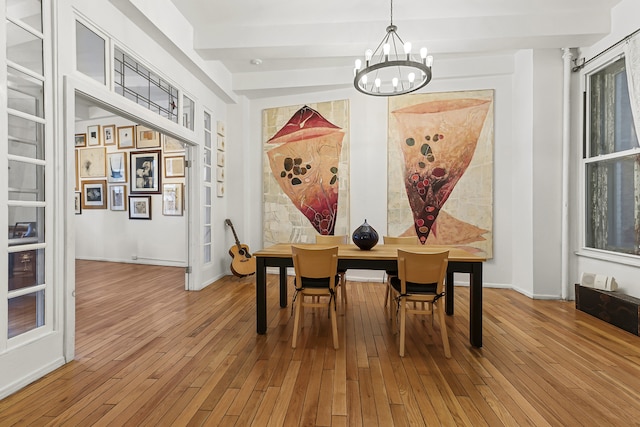 dining area featuring a chandelier, hardwood / wood-style flooring, and baseboards