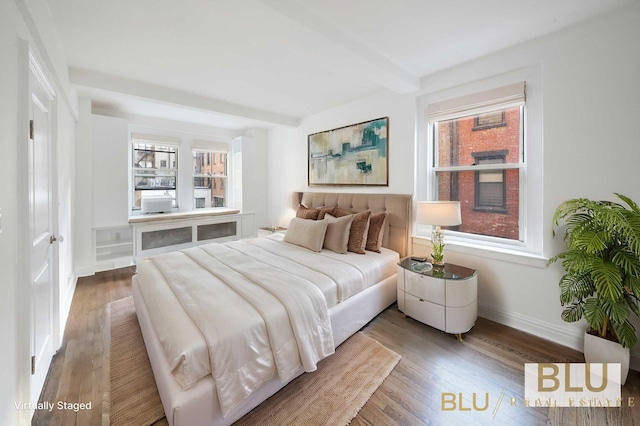 bedroom with baseboards, multiple windows, and wood finished floors