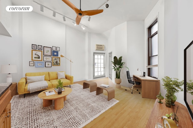 living area with rail lighting, visible vents, a high ceiling, light wood-style floors, and a ceiling fan