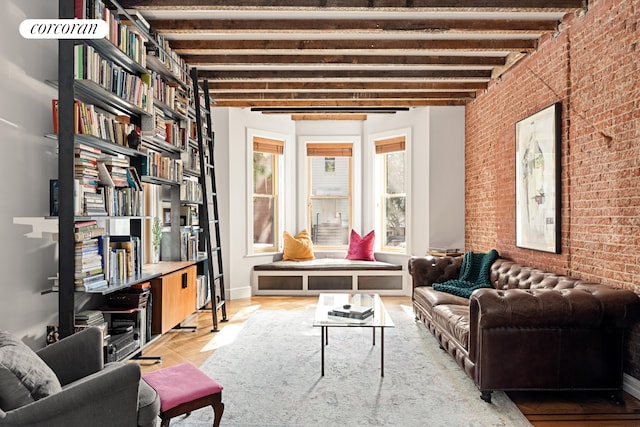 living area featuring brick wall, beam ceiling, and wood finished floors