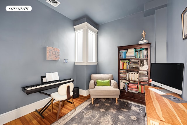 sitting room featuring baseboards, visible vents, and wood finished floors