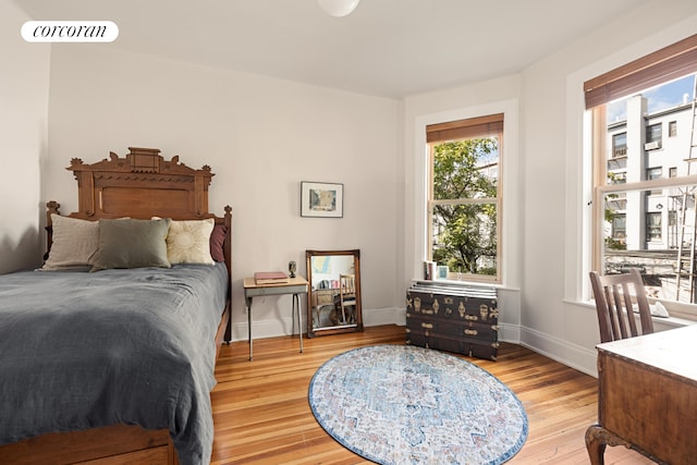 bedroom featuring baseboards, visible vents, and wood finished floors